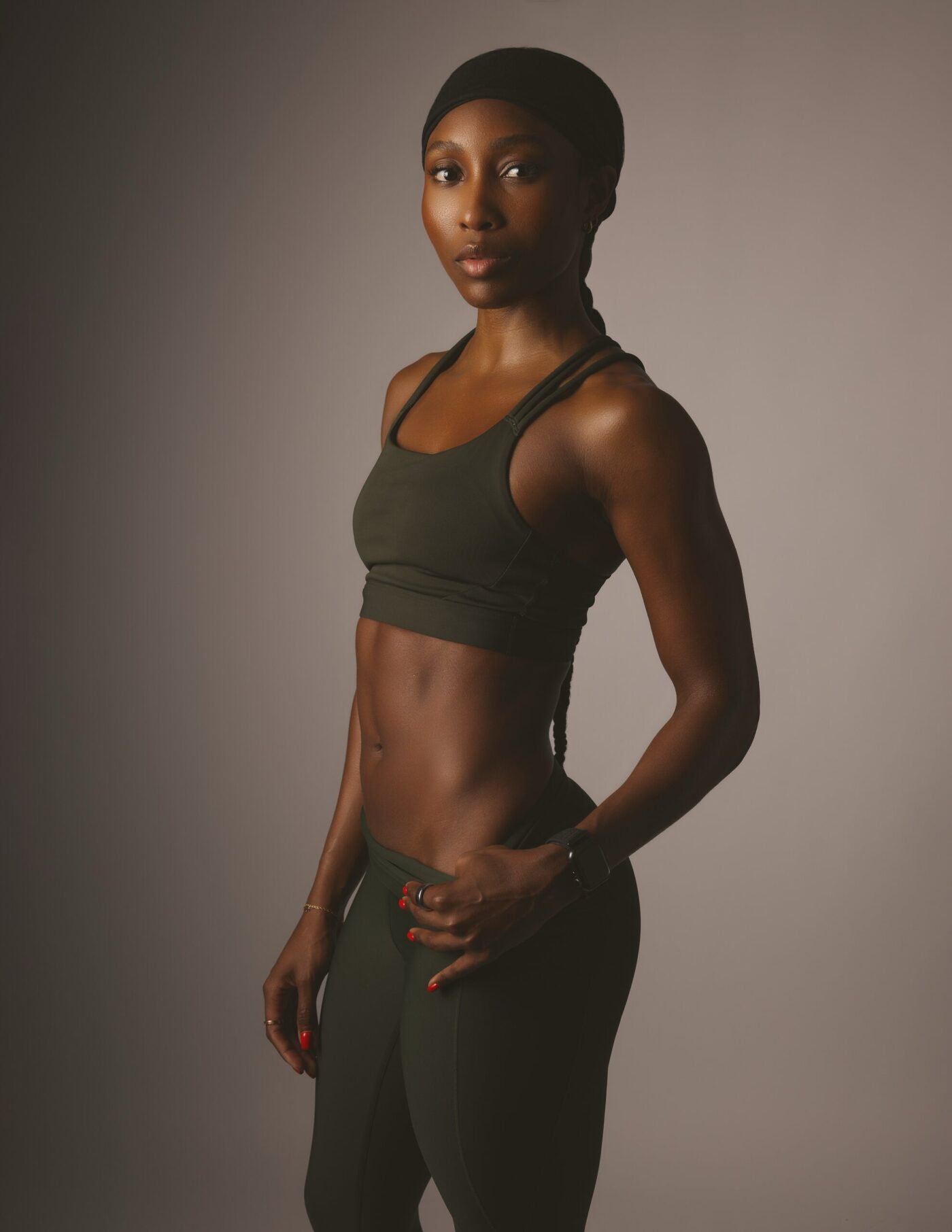 Francia Cooper in dark green activewear, posing in a studio